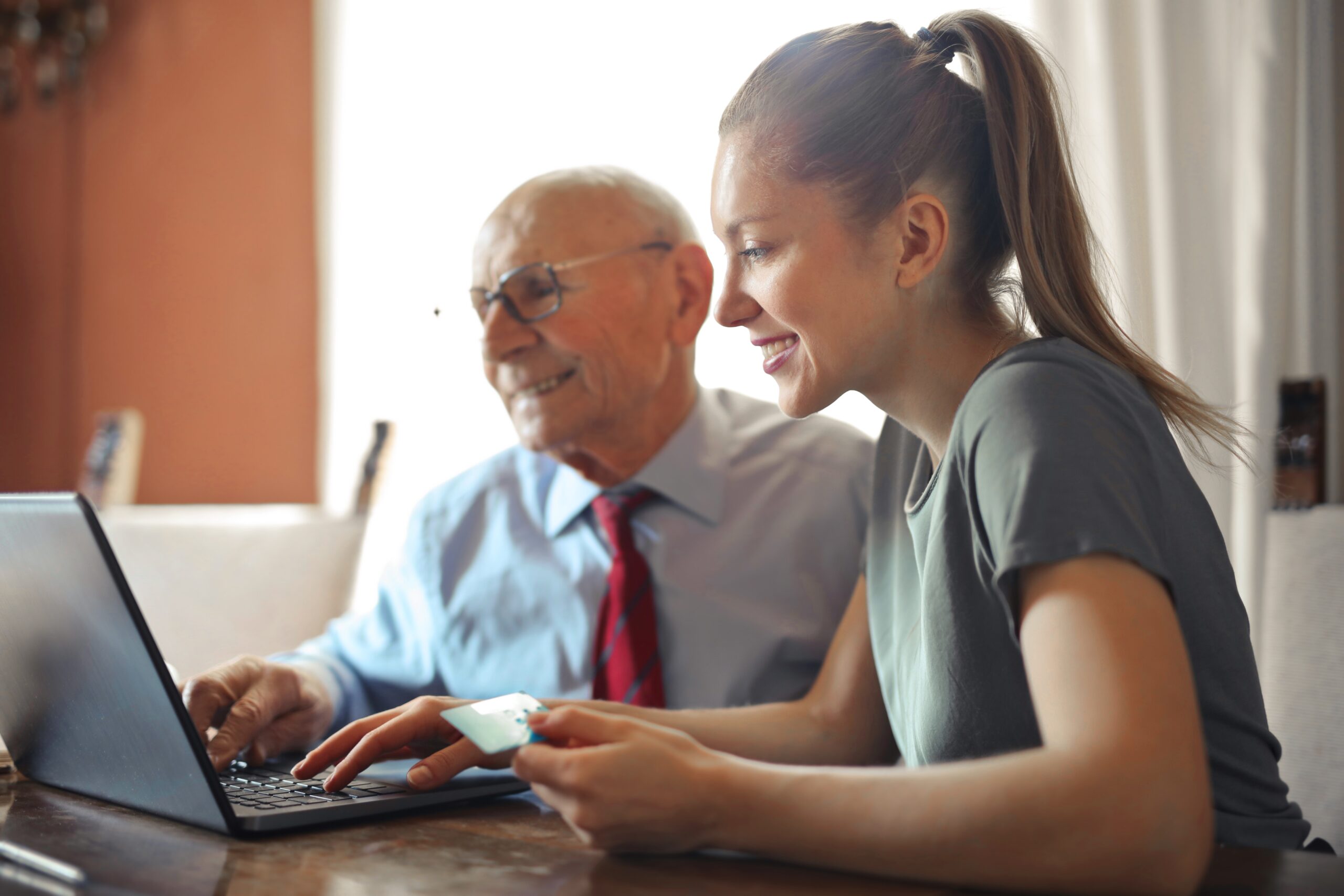 couple sat at desk, sharing laptop